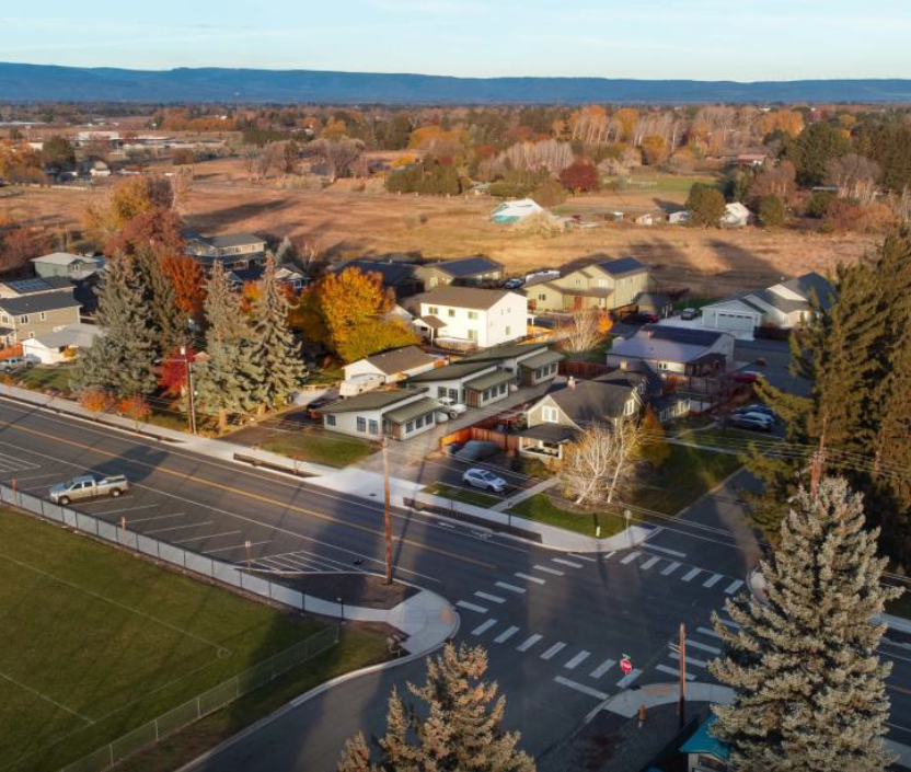 Rendering of three new houses on a lot in a neighborhood.